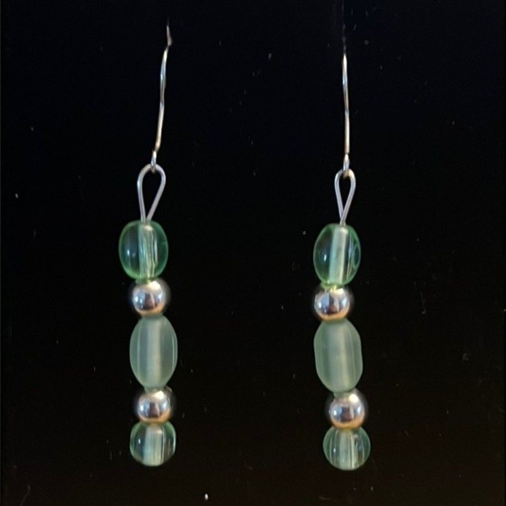 Handcrafted silver tone earrings with green colored beads.